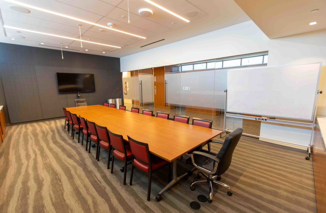 conference table with chairs and TV on wall