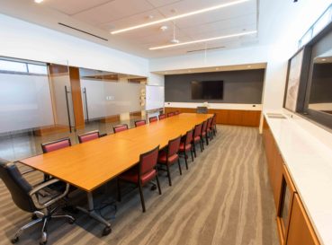 conference table with chairs and TV on wall