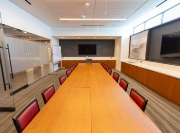 conference table with chairs and TV on wall